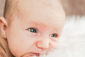 beautiful baby laying on comfy white fluffy blanket eyes wide open Utah fertility center east bay fertility utah gerber baby getty image white baby blue eyes super cute ivf fertility places near me
